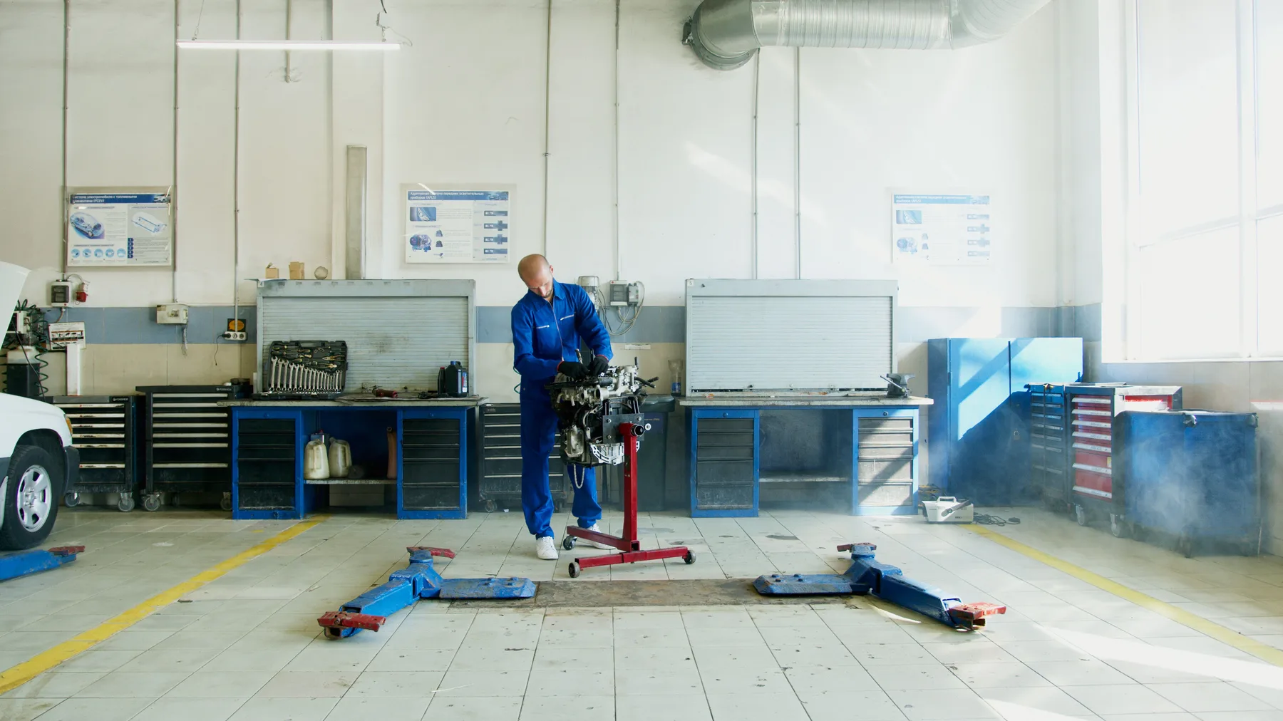 A mechanic working on a car engine in a workshop